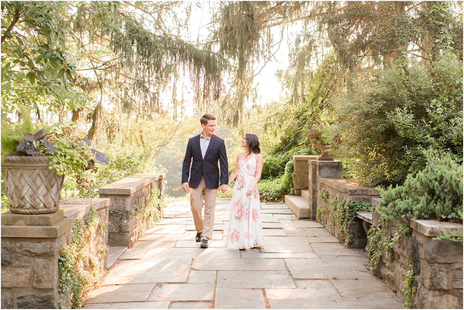 couple holds hands walking through Skylands Manor at sunset