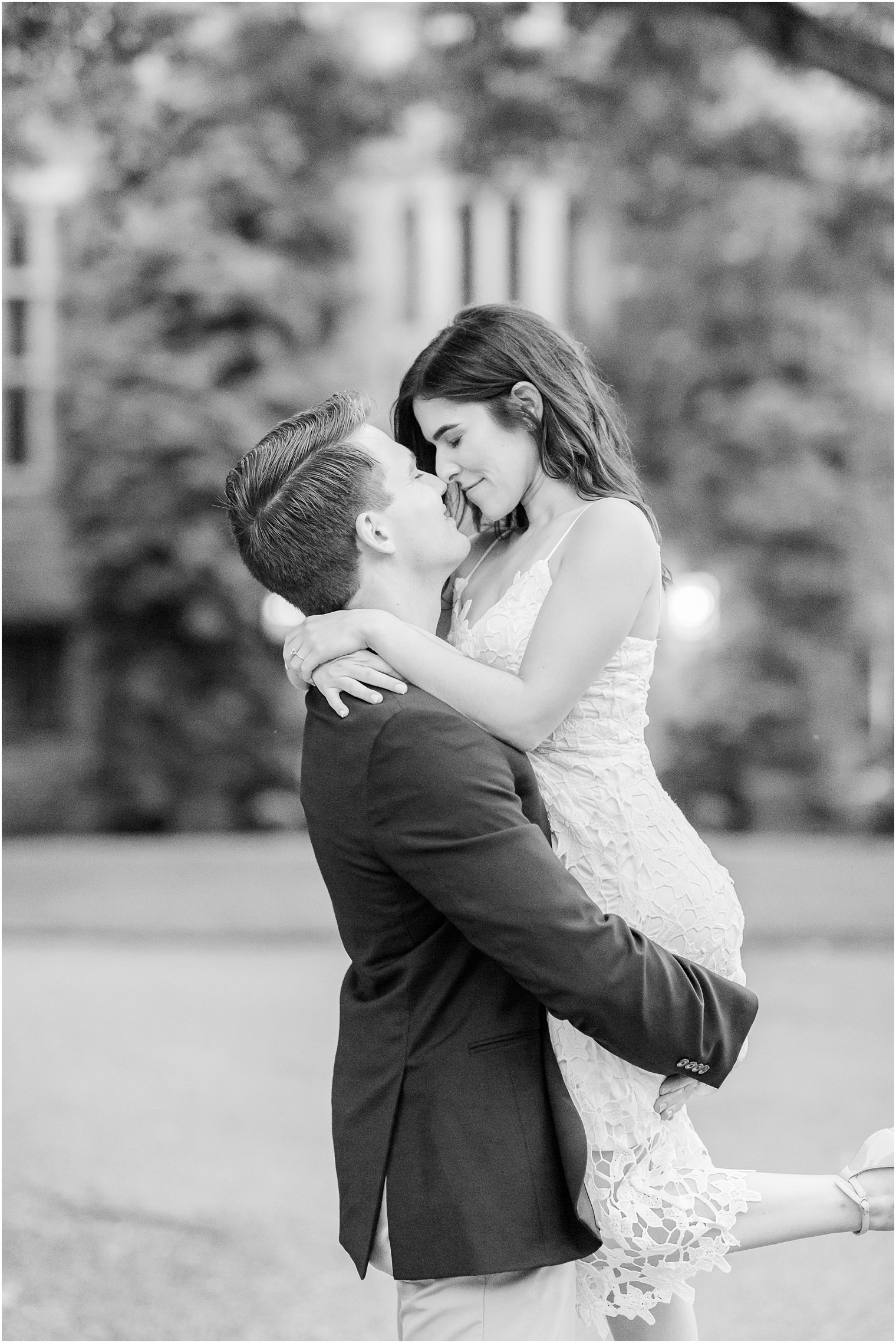 groom lifts bride up during NJ engagement session in gardens