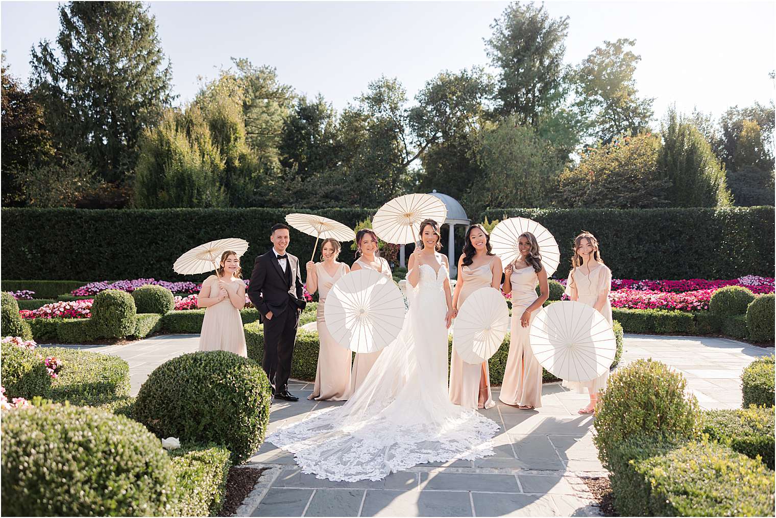 bride with her bridesmaids holding white parasols